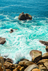 Rocky shore facing the Pacific Ocean in Acapulco, Mexico on a bright morning. The warm colors of...