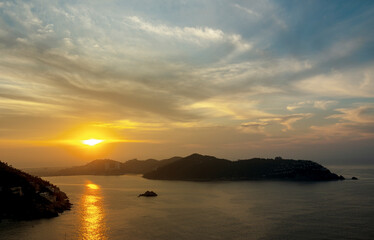 Beautiful sunrise at the entrance of the bay of Puerto Marques in Acapulco. The sun rises over the horizon announcing the arrival of a new day in this Mexican tourist destination.