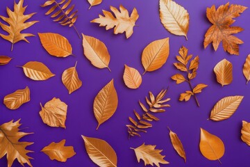 Obraz premium Violet Background Adorned with a Pattern of Diverse Dry Orange Metallic Leaves