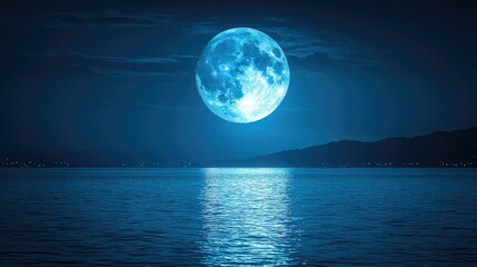 Fototapeta premium A luminous blue moon reflecting on a tranquil ocean at night.