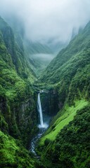 Obraz premium Majestic Waterfall Cascading Through Lush Mountain Valley