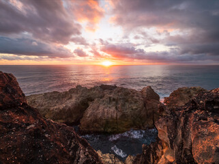 Obraz premium Coastal Sunrise Over Rocks