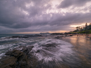 Colourful Coastal Sunrise with Waves on Rocks