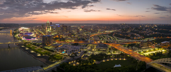 Fototapeta premium Cincinnati city, Ohio USA. View from above of brightly illuminated high skyscraper buildings in downtown district of American megapolis with business financial district at night