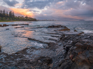 Colourful Coastal Sunrise with Waves on Rocks
