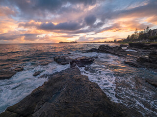 Fototapeta premium Colourful Coastal Sunrise with Waves on Rocks