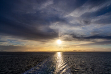 Golden Sunset Over Calm Ocean Water with Gentle Cloudy Sky