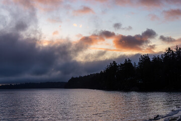 Tranquil Ocean Scene at Sunset with Colorful Clouds and Silhouetted Horizon