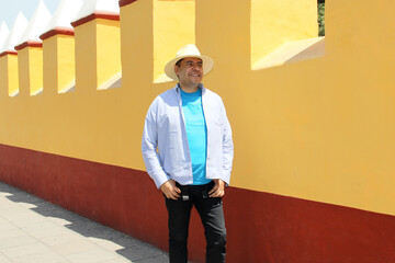 Dark-skinned Latino 40-year-old man with a hat walks as a tourist through the streets of a...