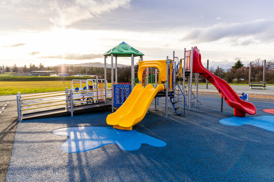 Colorful Accessible Playground Under a Vibrant Sunset in a Park Setting