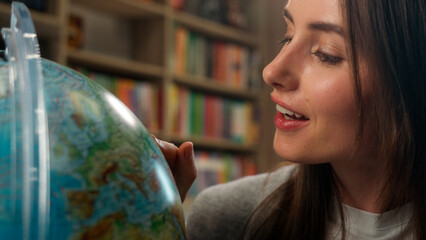 Excited Caucasian woman female girl student teacher library school geography lesson model planet...