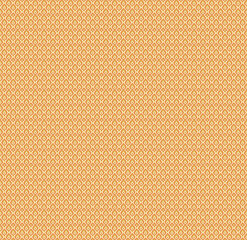 A rug with an orange, yellow, and brown pattern resembling a motif is partially covered with pieces of wrapping paper featuring abstract designs.