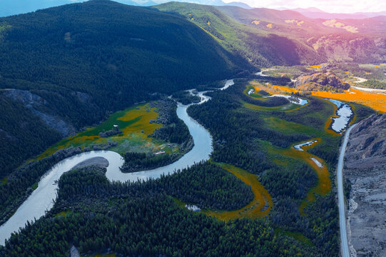 Beautiful aerial landscape winding river meander in mountains with forest trees with sunlight, Altai Russia, top view