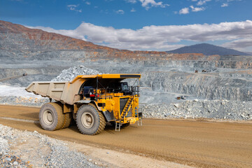 Big yellow mining truck transportation of gold ore. Open pit mine industry.