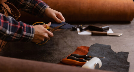 Leather craft or bag maker working industry background. Craftsman workplace with cutting tools