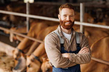 Worker of Livestock industry, sunlight. Smile handsome young man owner of dairy farm on background...
