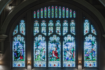 The stained glass window depicts a scene from the Bible, with Jesus