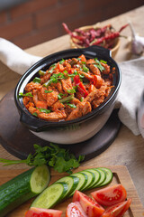 Baked meat in tomato sauce with herbs in a ceramic dish.