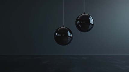 Two black sphere pendant lights hanging against a dark wall.