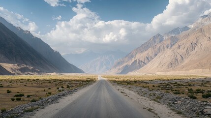 Serene Mountain Road Leading Through a Vast Landscape Under a Clear Sky