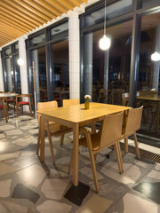 A restaurant with a wooden table and chairs