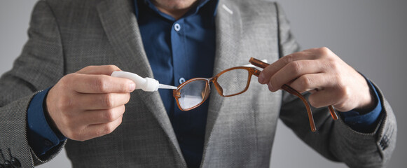 Caucasian man glues eyeglasses. Repairing