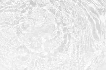 White water with ripples on the surface. Defocus blurred transparent white colored clear calm water surface texture with splashes and bubbles. Water waves with shining pattern texture background.