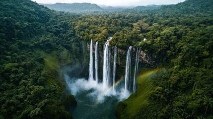 Fototapeta premium A breathtaking aerial view of cascading waterfalls surrounded by lush greenery and mist, showcasing nature's beauty and tranquility.