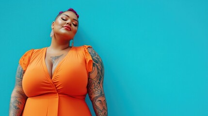 Obraz premium A radiant plus-size woman with full sleeves of geometric tattoos, dressed in a vibrant orange outfit, standing confidently on a solid bright blue background.