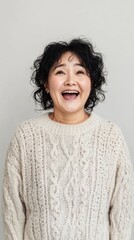 A realistic portrait of a happy plump Asian woman with a surprised joyful face, middle-aged, wearing a casual sweater, captured against a minimalistic light gray background.