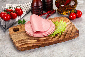 Sliced boiled sausage over board