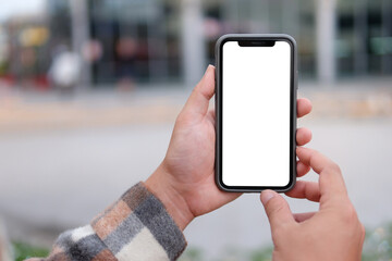 Man holds and touches a smartphone with a vertical white screen to take a photo.