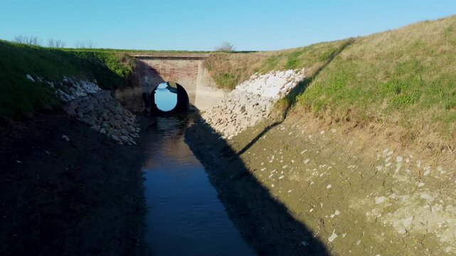 low flight with drone inside an irrigation canal that passes under the bridge
