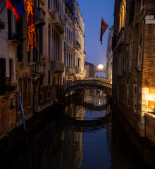 Venetian canal in the evening. Reflection of the medieval city in the water.