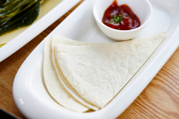 식탁 위에 토르티야가 양념과 함께 놓여 있는 모습