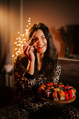 Woman enjoying sushi in pajamas while relaxing at home with warm lighting