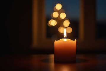 A lit candle illuminates a setting with bokeh lights