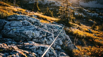 Rope on rocky mountainside at sunset.