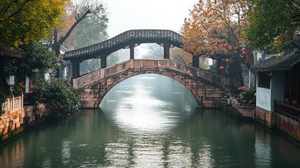 Fototapeta premium Ancient Stone Arch Bridge Over Calm Canal Water