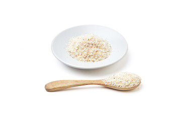 Psyllium husk powder on white plate and wooden spoon isolated on white background. It's used as a laxative to treat constipation.