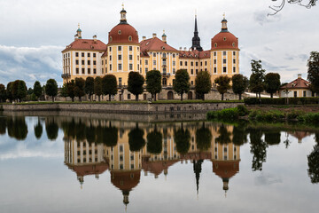 Landscape with a castle and its reflection on the surface of a body of water in Moritzburg, Germany.