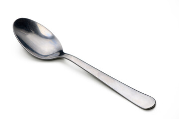 Shiny silver spoon resting on a clean white surface reflecting gentle light