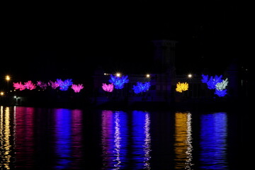 El Retiro’s illuminated trees shimmer on the tranquil lake in Christmas night