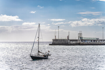 Obraz premium Sailboat Anchored Near a Harbor on a Peaceful Sunny Day, Funchal, Madeira