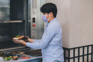 Chef use Dumbwaiter Lift elevator in a kitchen of Restaurant or Hotel used for carrying food ready...
