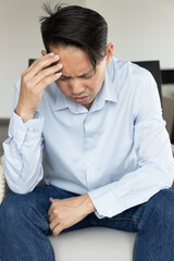 Stressful and mentally exhausted Asian Man feeling exhausted with migraine headache