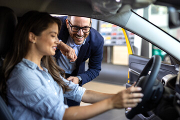 Car Renting Service. Young Woman Driver Taking Keys From Manager While Sitting In Rental Auto,...