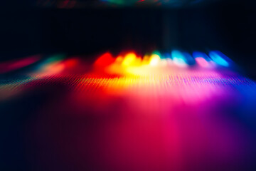 Vibrant colorful light leaks on dark blurred background. Modern design, ethereal theme, abstract visual. Retro film lens flare bokeh analog vintage photo overlay or screen filter effect