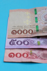 Thai banknotes on blue background.