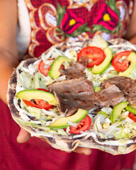 Tlayuda is a thin, crispy tortilla topped with black beans, beef jerky, tomato and avocado. Is a traditional Mexican food from Oaxaca.